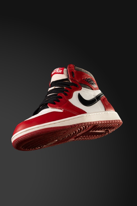 A red and black sneaker on a dark backdrop