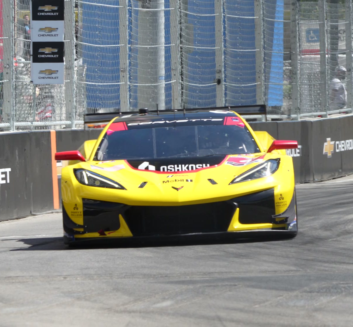 A yellow race car with a mirror finish coming through a corner