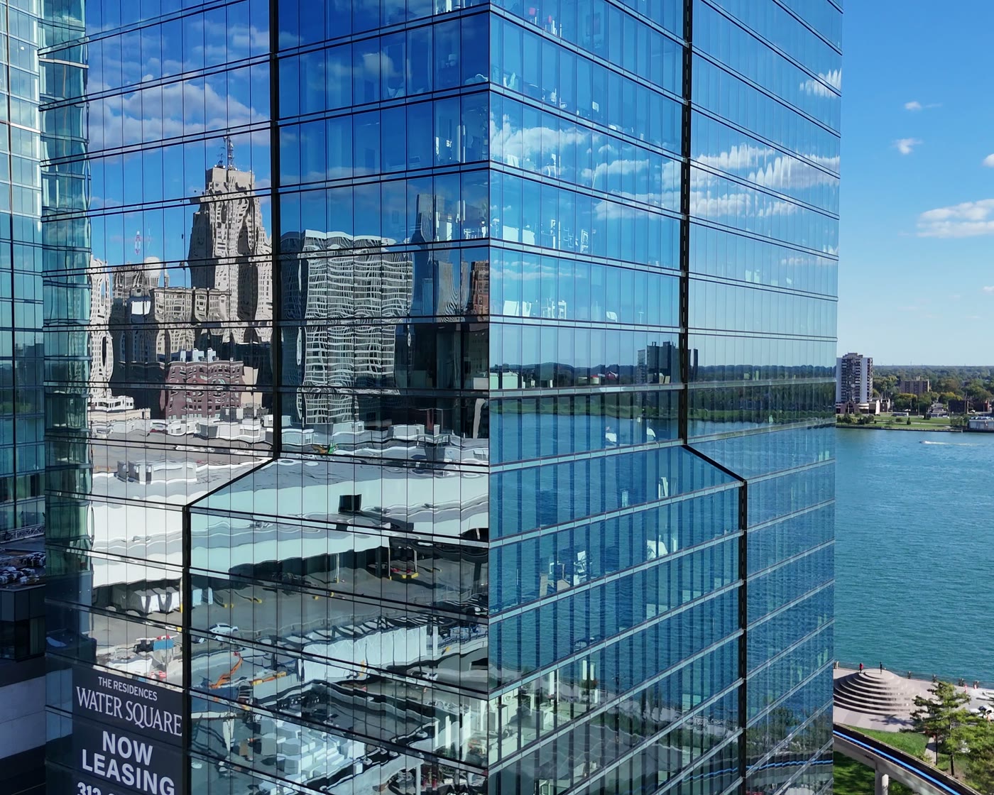 A glass residential tower over the Detroit River